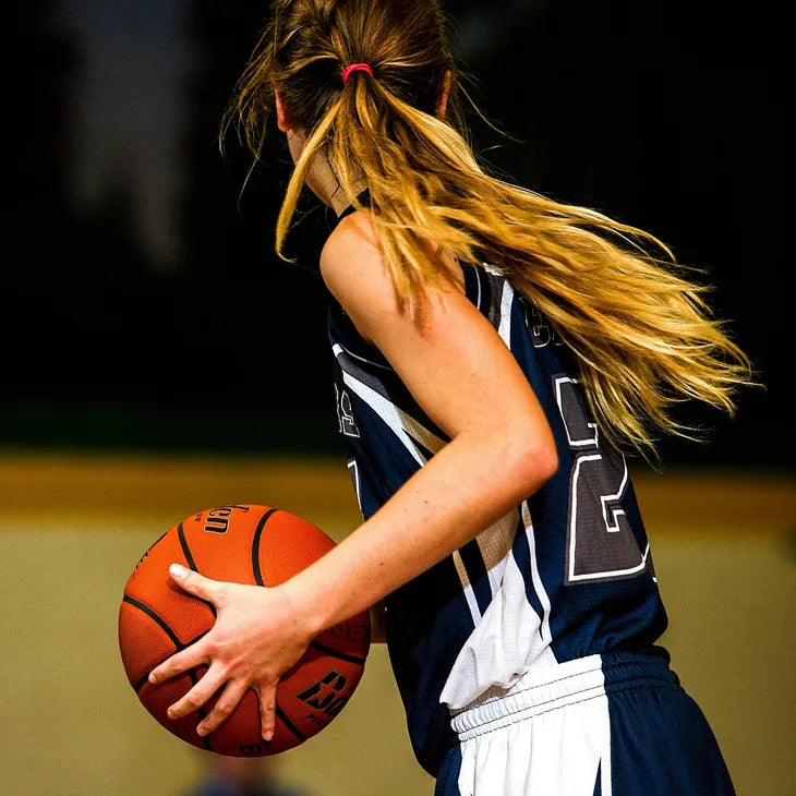 A teen holding a basketball on an court