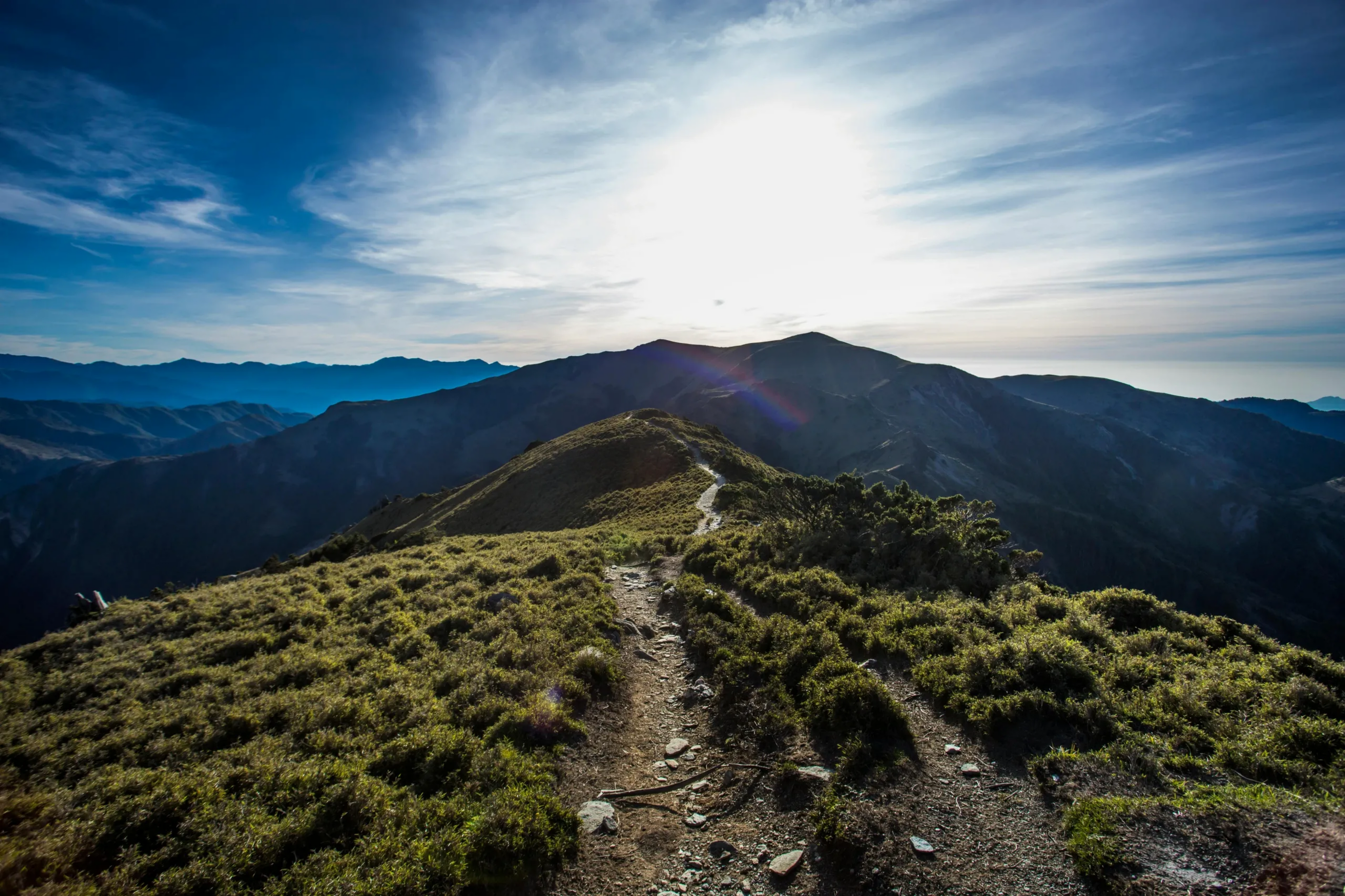 Mountain landscape with a sunlit peak and clear sky